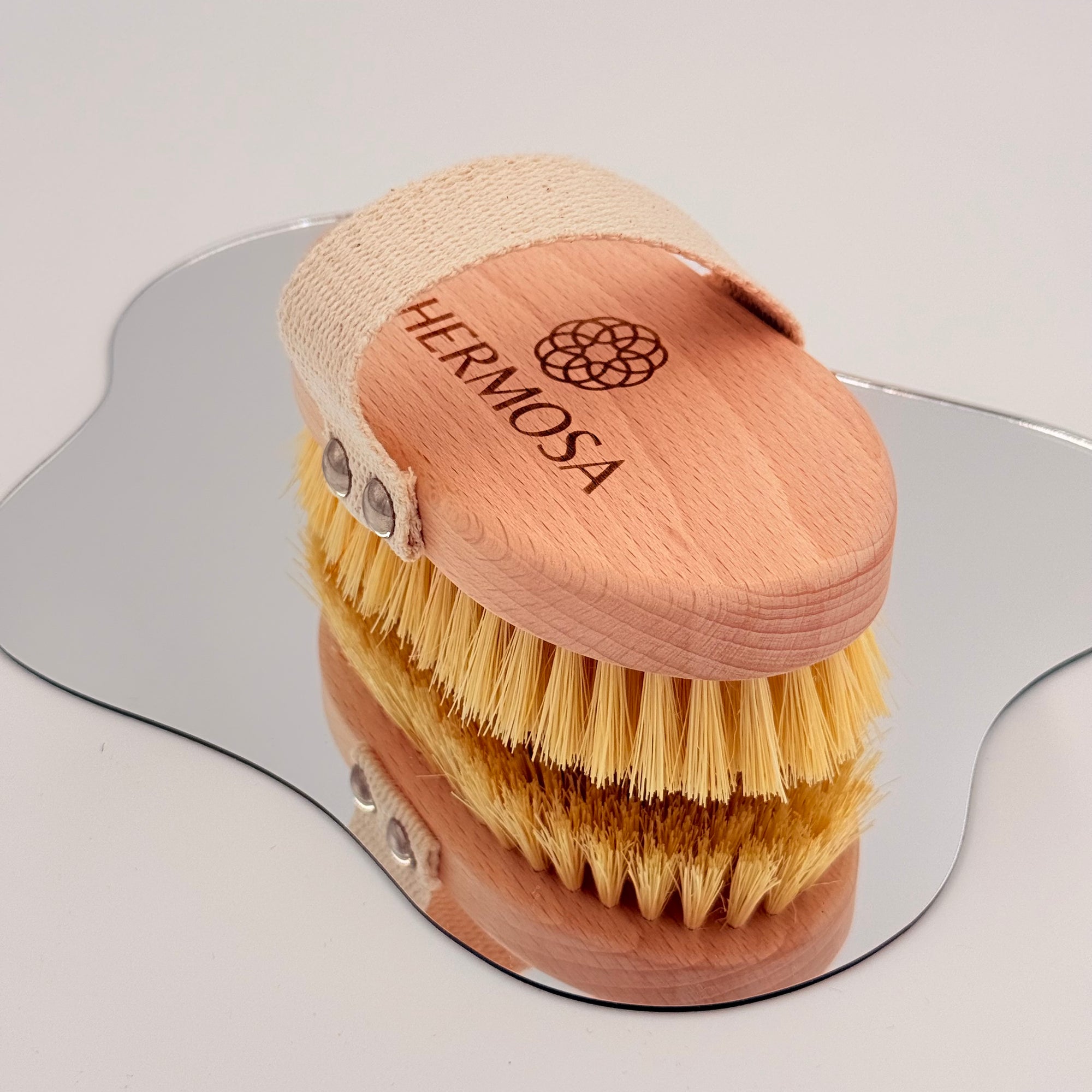 Szczotka Hermosa w pozycji pionowej, odbijająca się w lustrze - pełne włosie i uchwyt.