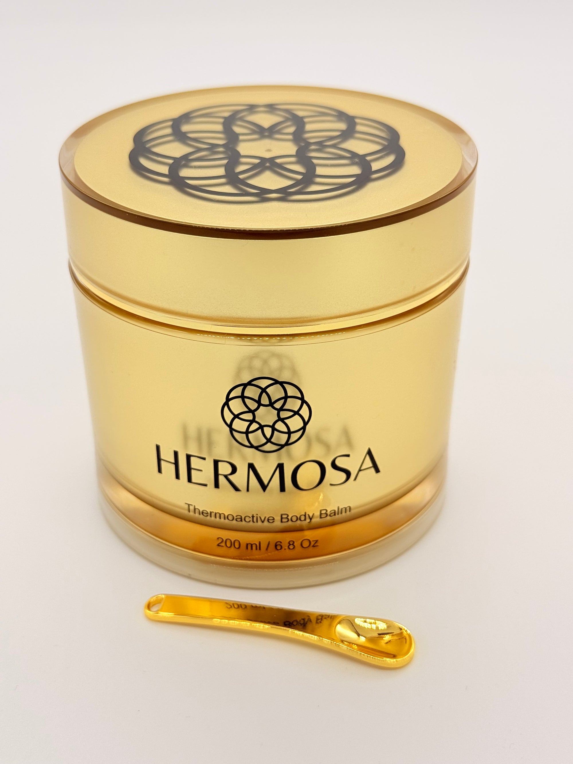 Wieczko z logo Hermosa i złota łyżeczka - branding premium i styl